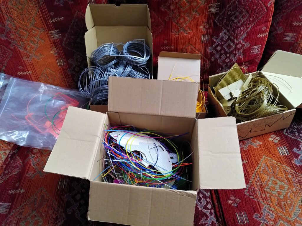 Kartons und Tüten voll mit farblich sortierten Druckresten und Fehldrucken