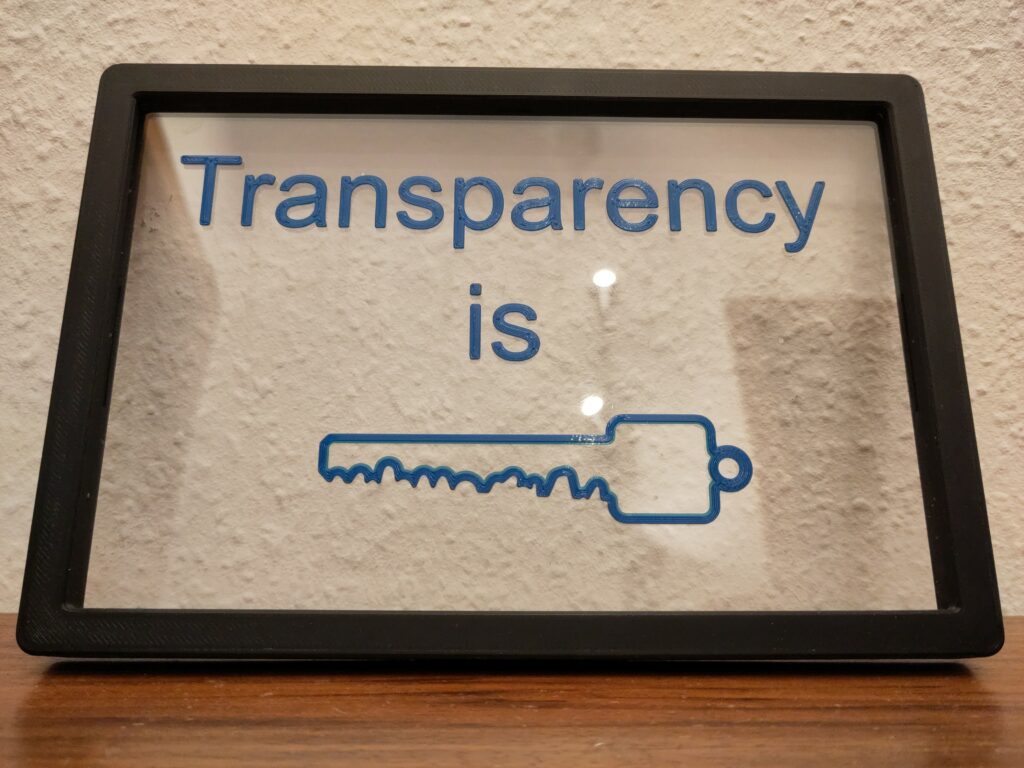 3d printed test on an sheet: "Transparency is" and the symbol of an key.