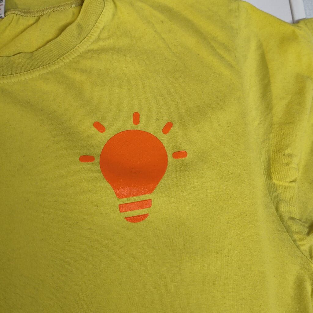 The T-Shirt with the screen printed symbol of an light bulb on it.